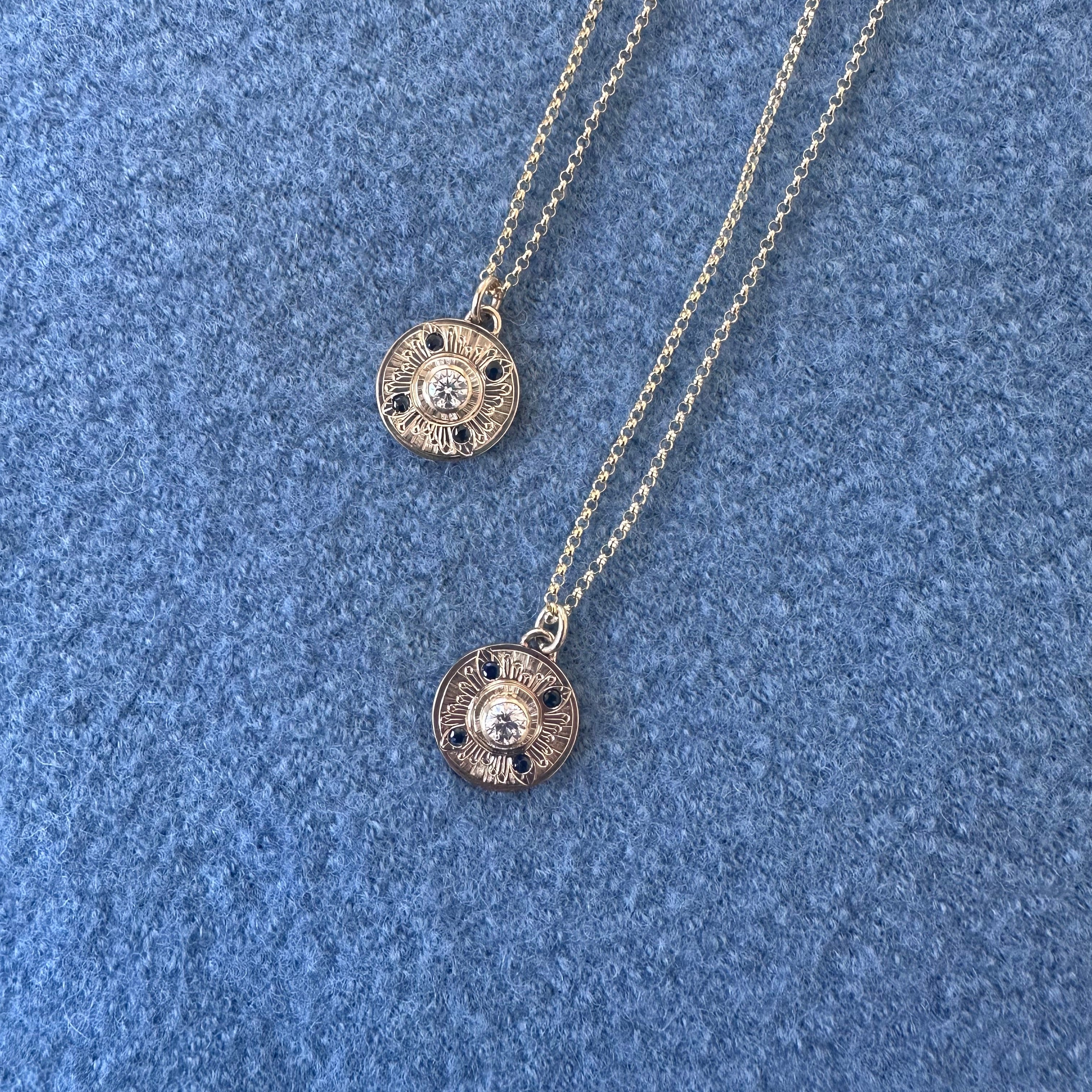 14k yellow gold matching necklaces with diamond and sapphires set on a hand engraved disc pendant
